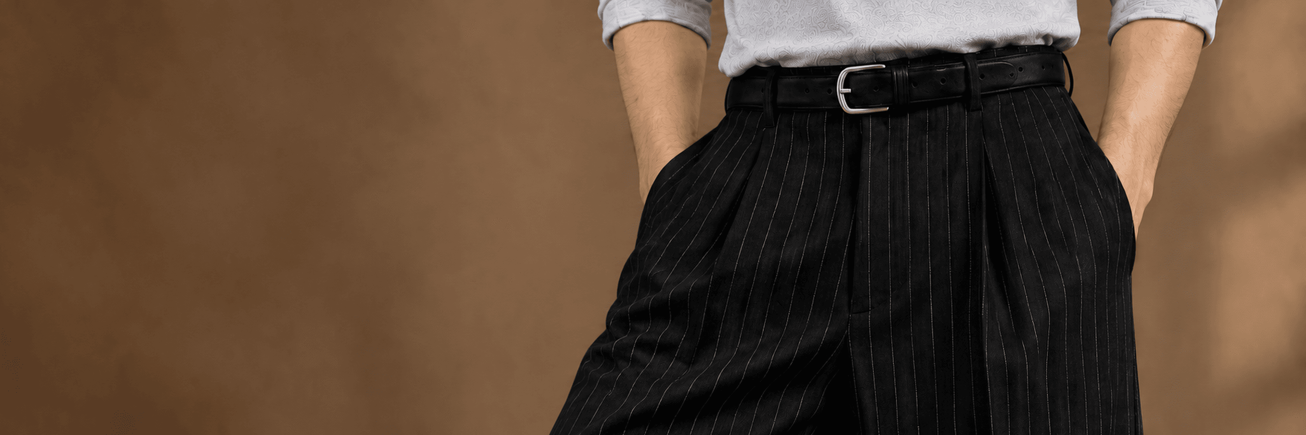 Model wearing high-rise pleated AEVRO trousers