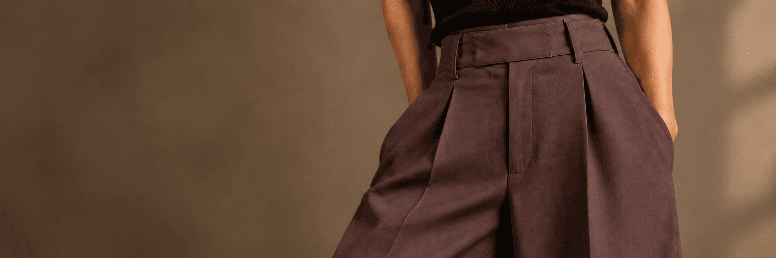 Model wearing high-rise pleated AEVRO trousers